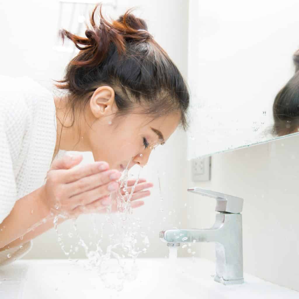 Woman washing her oily face